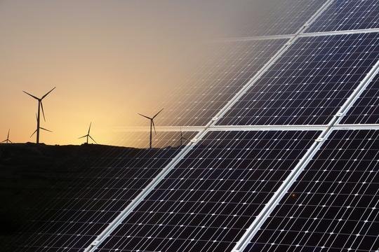 Zonnepanelen met windturbines in de avondzon